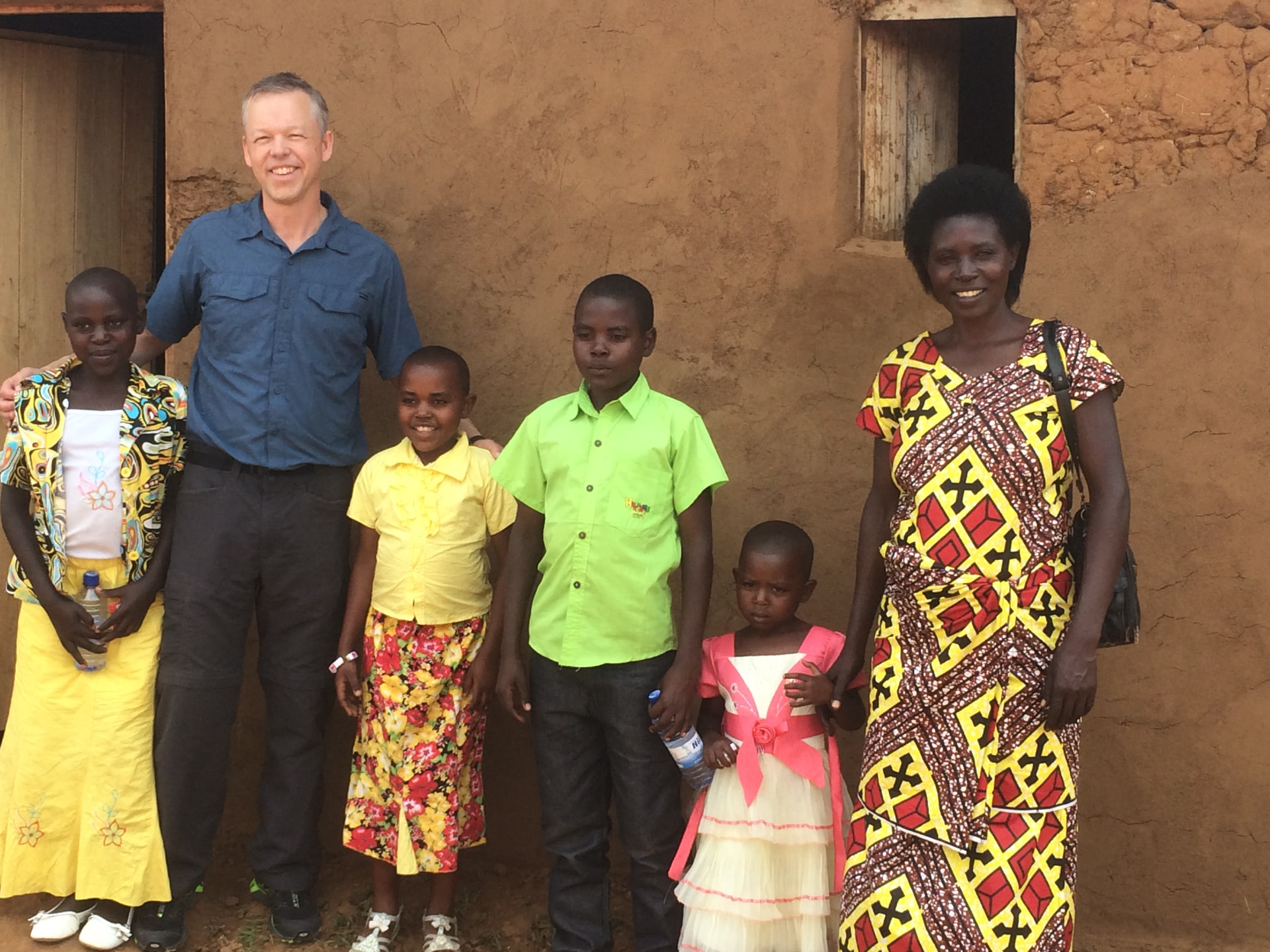 A sponsored family standing together outside their home