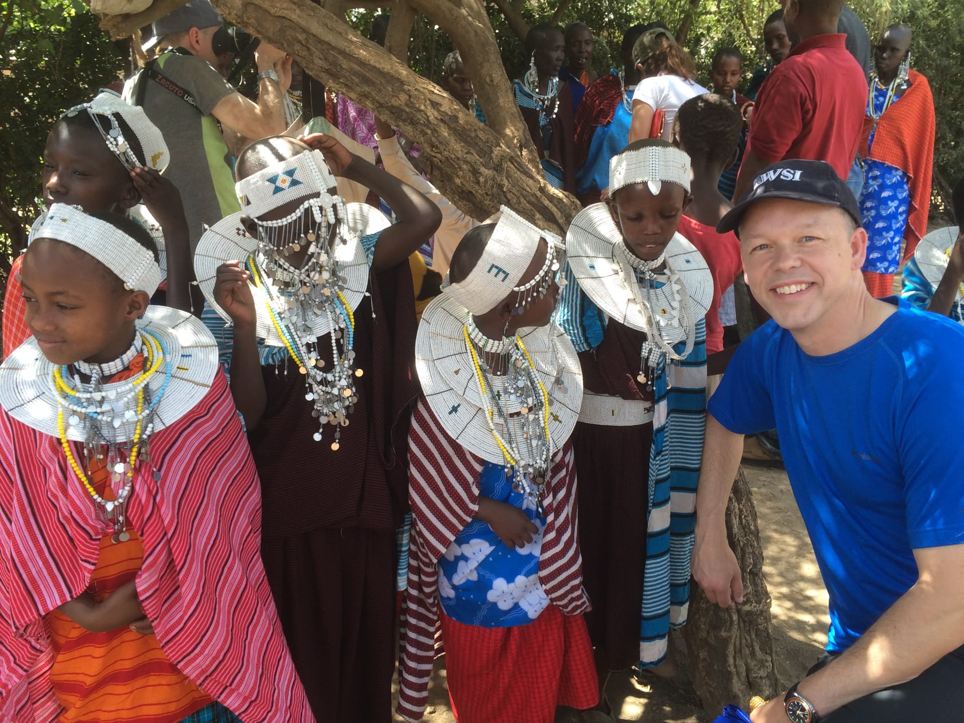 Children showing a handmade beaded craft to a visitor