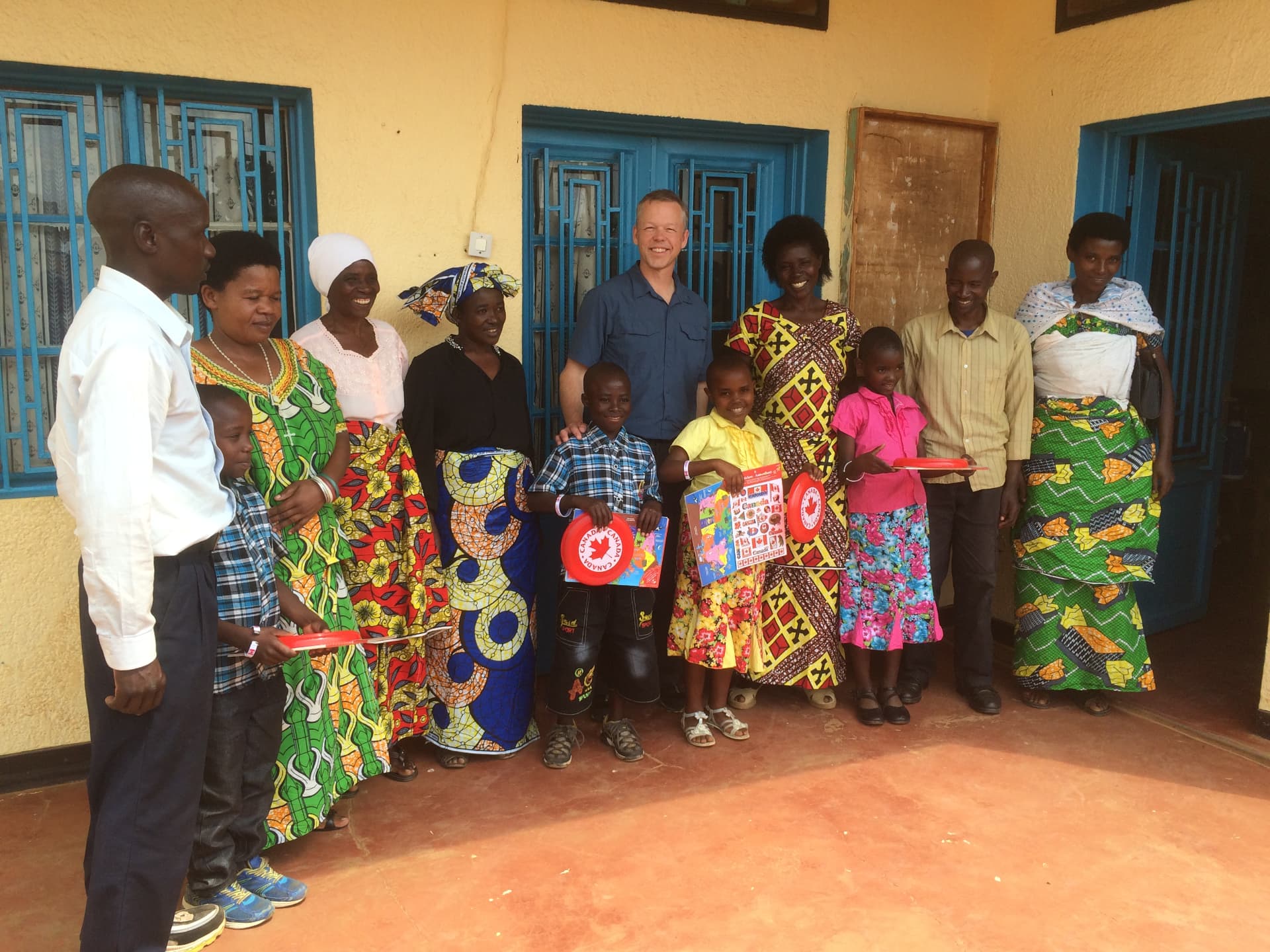 Sponsored children and their families meeting the visiting team outside their home